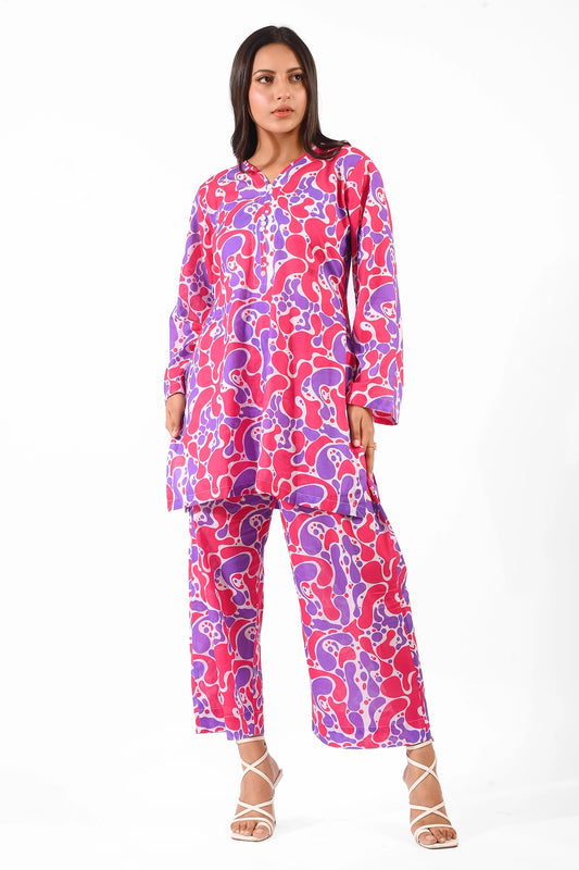 Full-body view of a model wearing a vibrant printed kurta and pants in shades of pink and purple. BOLDSTEP BOLDSTEP.PK