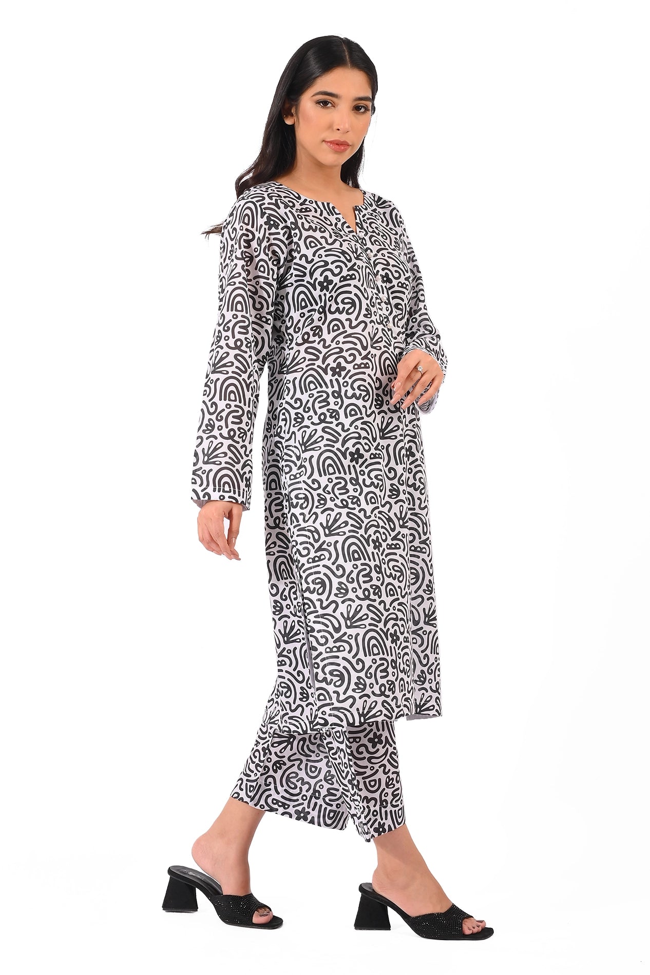 Side profile of a stylish black and white abstract print dress paired with matching trousers, showcasing a flowing silhouette and elegant design. BOLDSTEP BOLDSTEP.PK