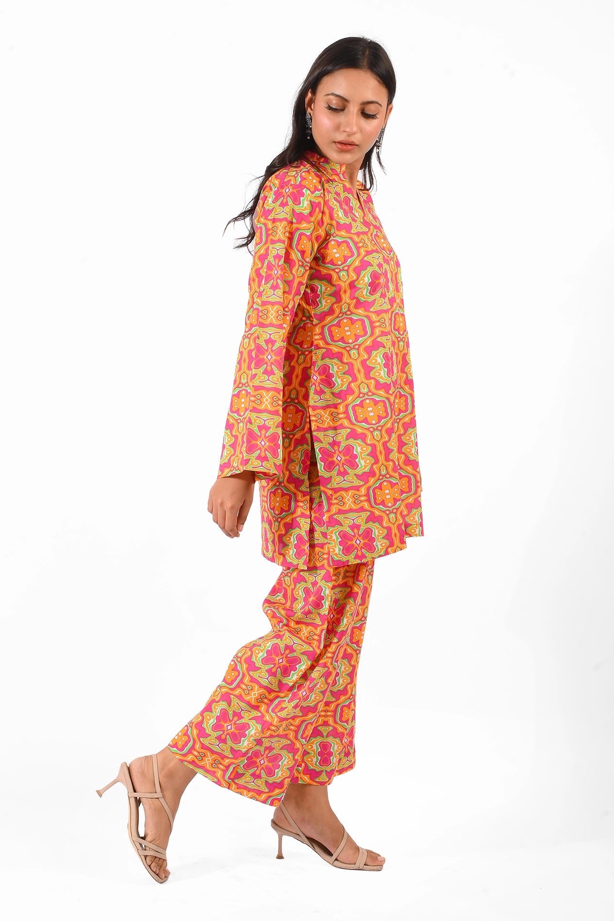 A side view of the same outfit, showcasing the kurta's straight cut and full sleeves, complemented by the model's beige heels and minimal accessories BOLDSTEP BOLDSTEP.PK