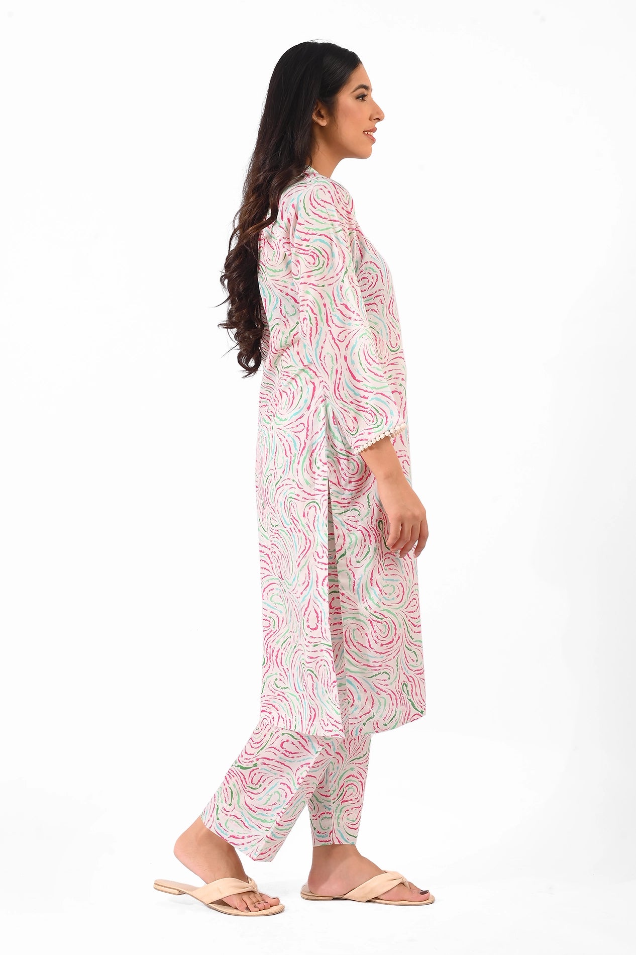 A side view of a woman modeling the pastel-patterned kurta set. The abstract pink and green swirl design is prominent, and she pairs the outfit with flowing long hair and minimal accessories BOLDSTEP BOLDSTEP.PK