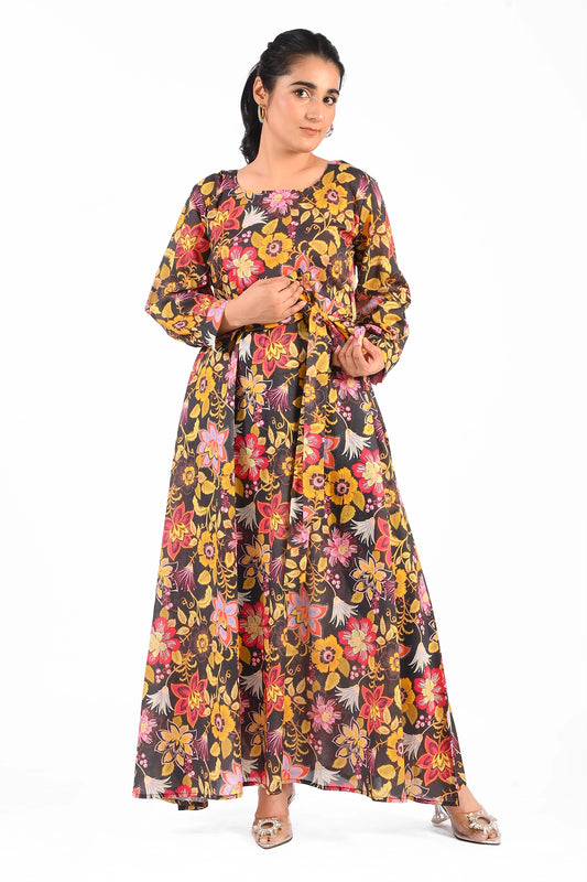 Full-length floral printed black dress with vibrant yellow, pink, and red flower patterns, accessorized with a matching belt and elegant silver heels. The dress features long sleeves and a round neckline. BOLDSTEP BOLDSTEP.PK
