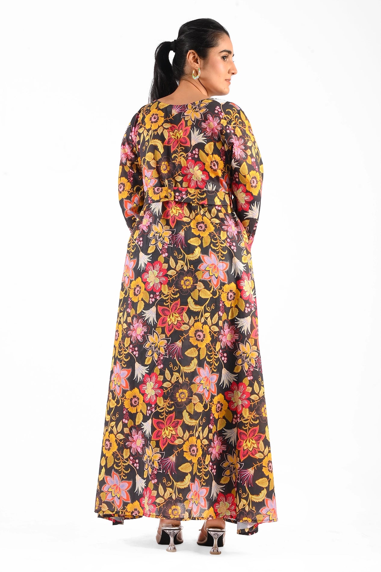 Back view of the black floral maxi dress adorned with vibrant flower prints and a tied belt, highlighting the dress's elegance and full-length design. BOLDSTEP BOLDSTEP.pk