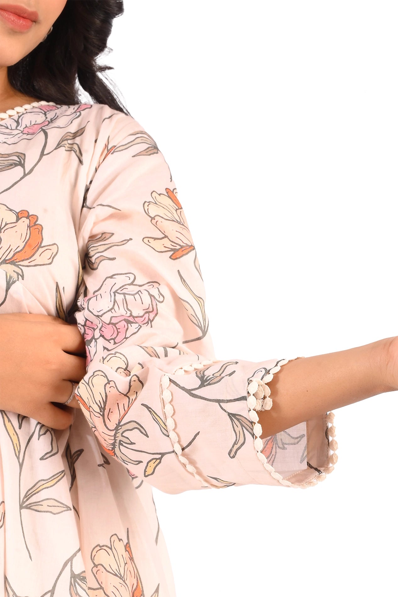 Close-up of the sleeve detailing of a pastel pink floral dress. The sleeve features intricate lace trimming that enhances its overall sophistication. BOLDSTEP BOLDSTEP.PK