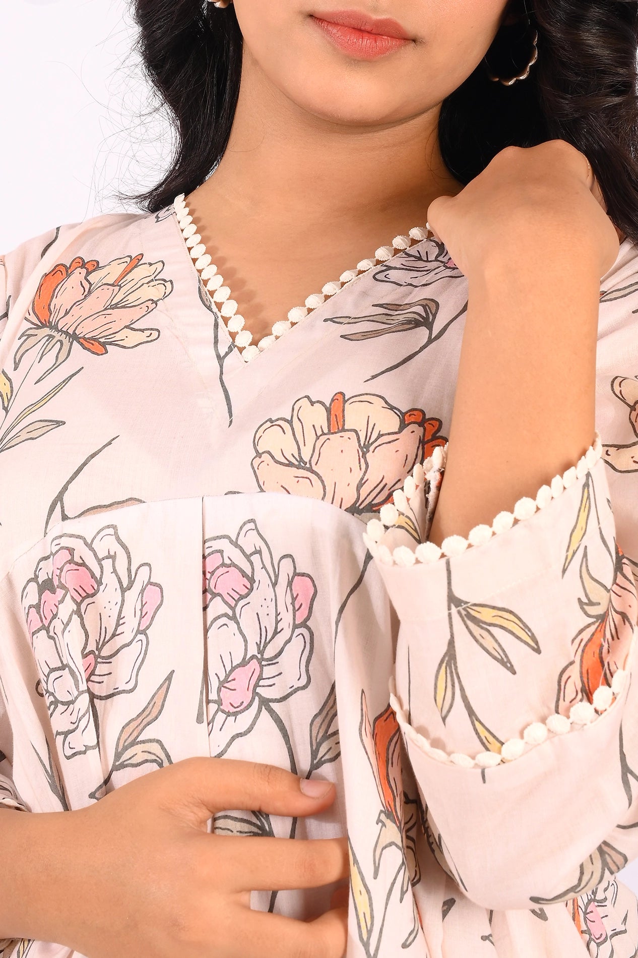 A close-up of the V-neckline of the pastel pink floral dress. The neckline is outlined with delicate lace, adding a refined touch to the feminine floral print. BOLDSTEP BOLDSTEP.PK