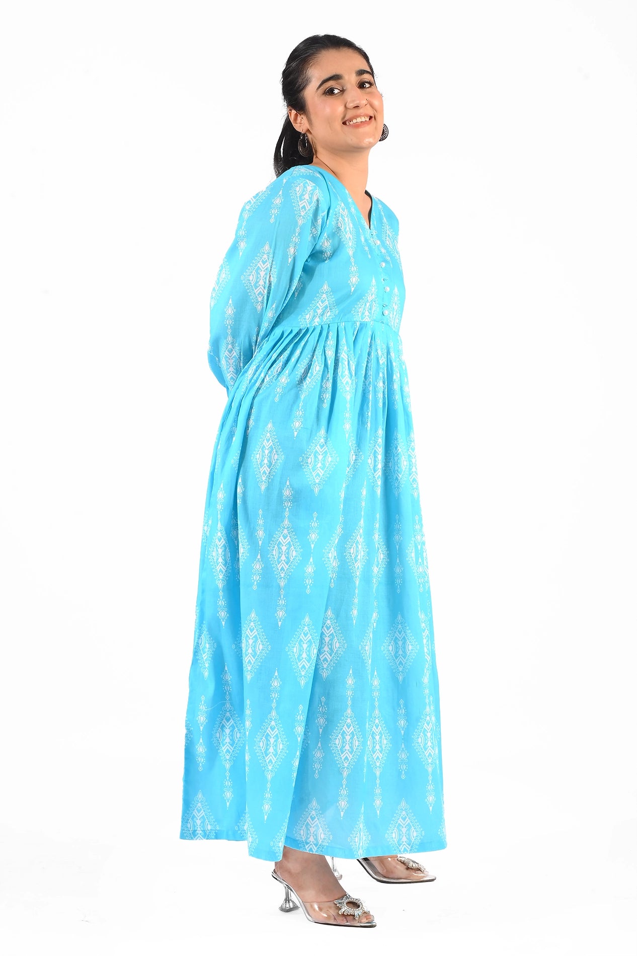 A woman in the same blue maxi dress is seen in a side profile, showcasing the flowy fabric and intricate white print of the dress. BOLDSTEP BOLDSTEP.PK