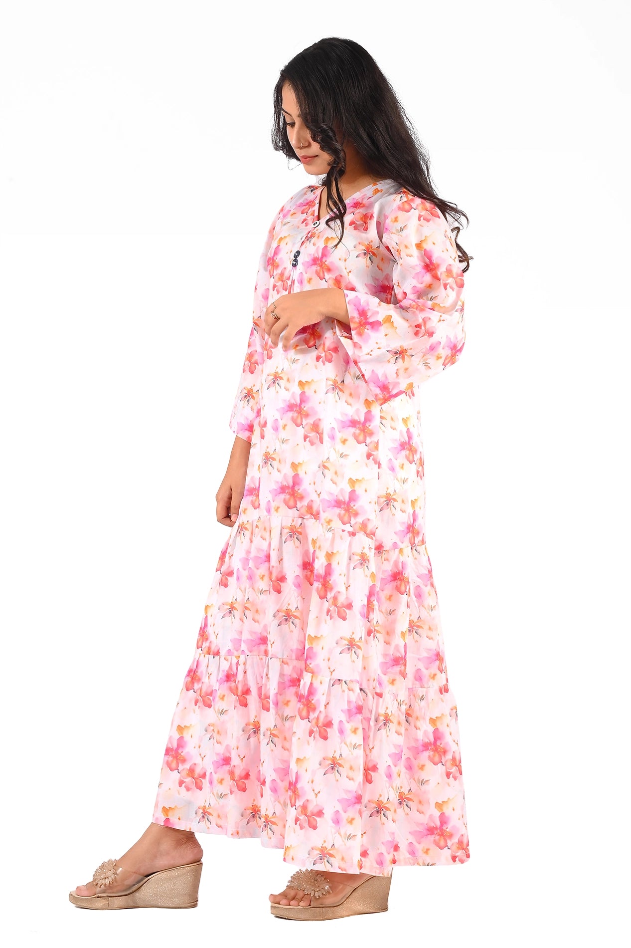 Side view of the pink floral maxi dress highlighting its tiered flowy structure, showing the model's profile with loose curls and minimal accessories. BOLDSTEP BOLDSTEP.PK