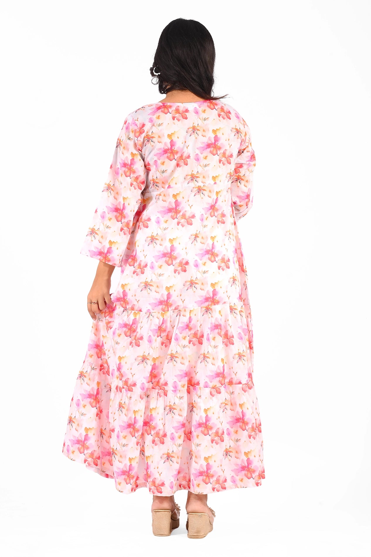 Back view of the pink floral maxi dress, showcasing its tiered detailing and flowy fabric, complemented by beige wedge sandals. BOLDSTEP.PK BOLDSTEP