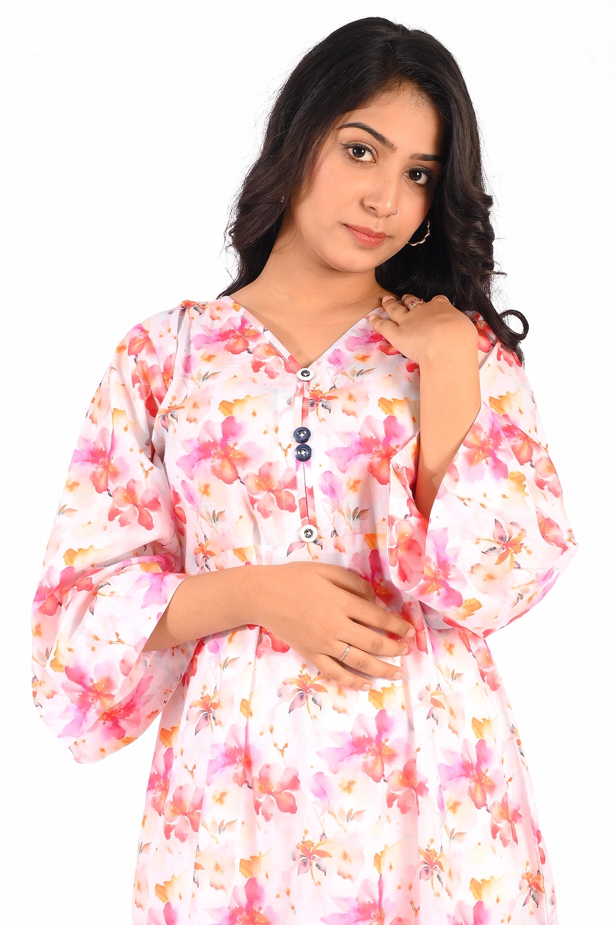 Close-up of the upper half of the pink floral maxi dress, focusing on the V-neckline, button detailing, and floral print, with the model gracefully touching her hair. BOLDSTEP BOLDSTEP.PK