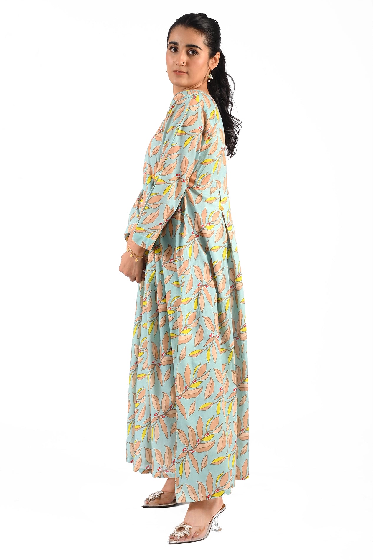 A side profile of the dress, highlighting the graceful fall of the fabric and the intricate print of the peach and yellow leaves against the blue backdrop. BOLDSTEP BOLDSTEP.PK