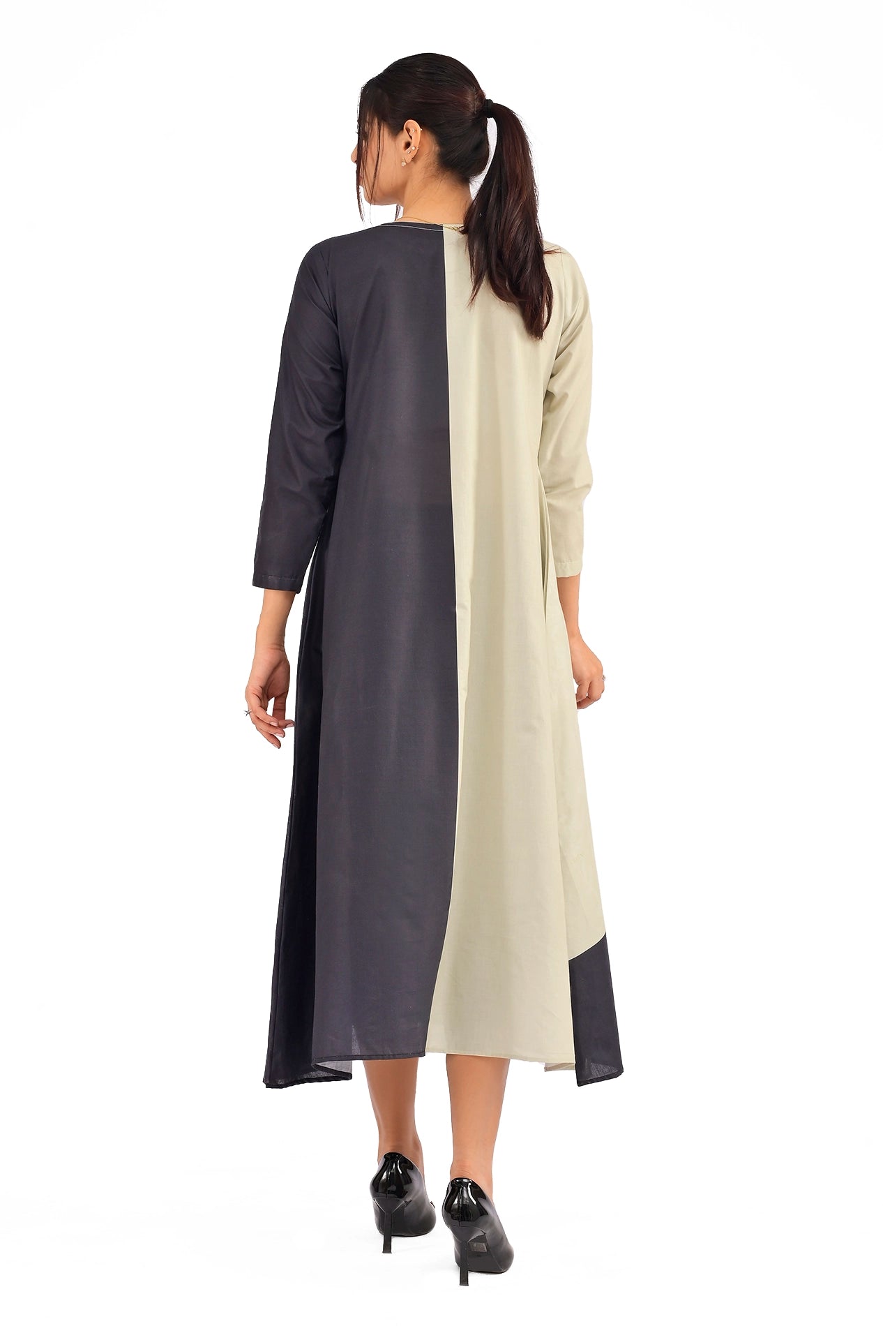 Back view of the dress highlighting the symmetrical beige and black panel design with flowing fabric and minimalistic detailing.BOLDSTEP BOLDSTEP.PK