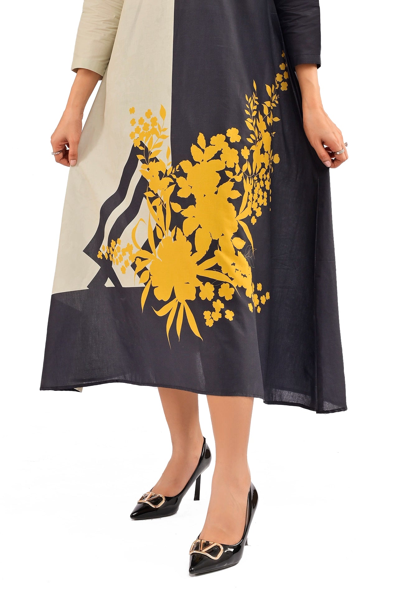A detailed view of the floral yellow design at the bottom hem of the dress, paired with stylish black heels for an elegant touch. BOLDSTEP BOLDSTEP.PK
