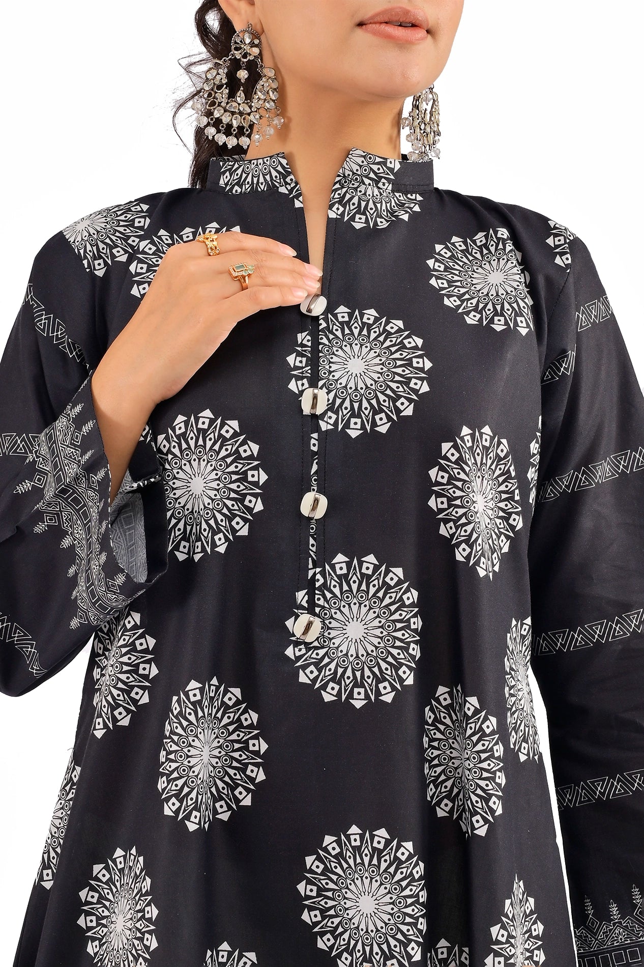 Close-up of a black dress highlighting metallic button details, high-collar neckline, and elegant white motif patterns. BOLDSTEP BOLDSTEP.PK