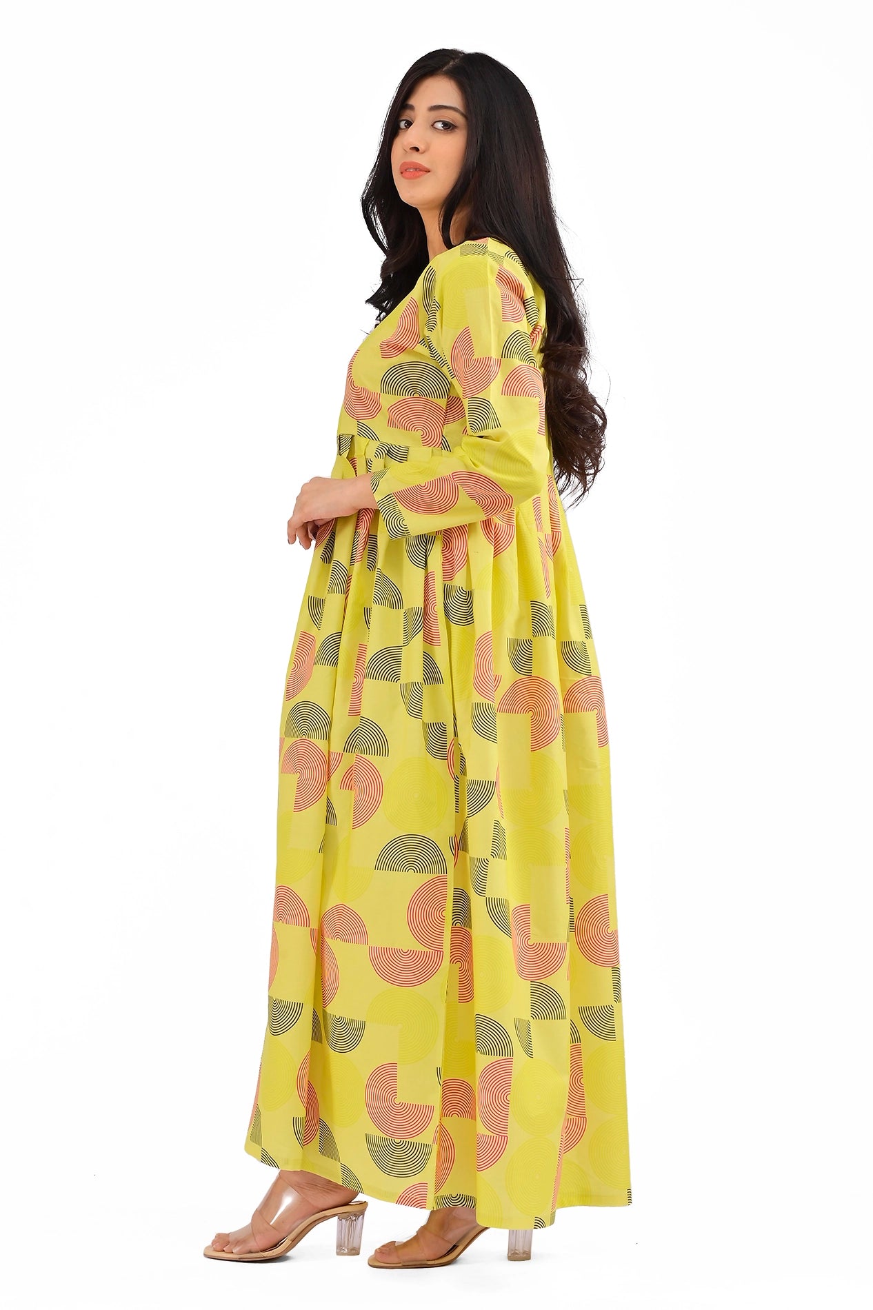 A vibrant yellow dress with a modern geometric pattern featuring semi-circular shapes in coral, black, and gradients. The model showcases the side view, highlighting the relaxed A-line silhouette and full-length sleeves. BOLDSTEP BOLDSTEP.PK