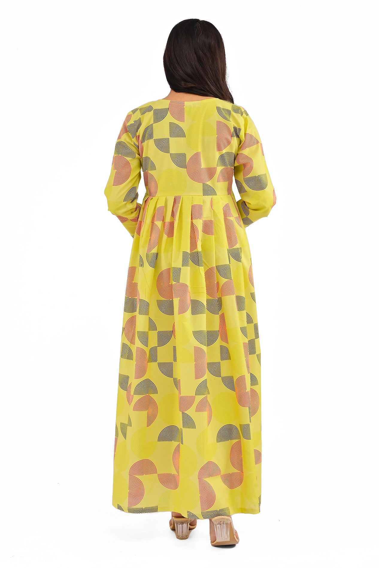 Back view of the yellow dress with a modest round neckline and a continuation of the semi-circular geometric pattern. The floor-length hemline is showcased as the model stands gracefully. BOLDSTEP BOLDSTEp.PK