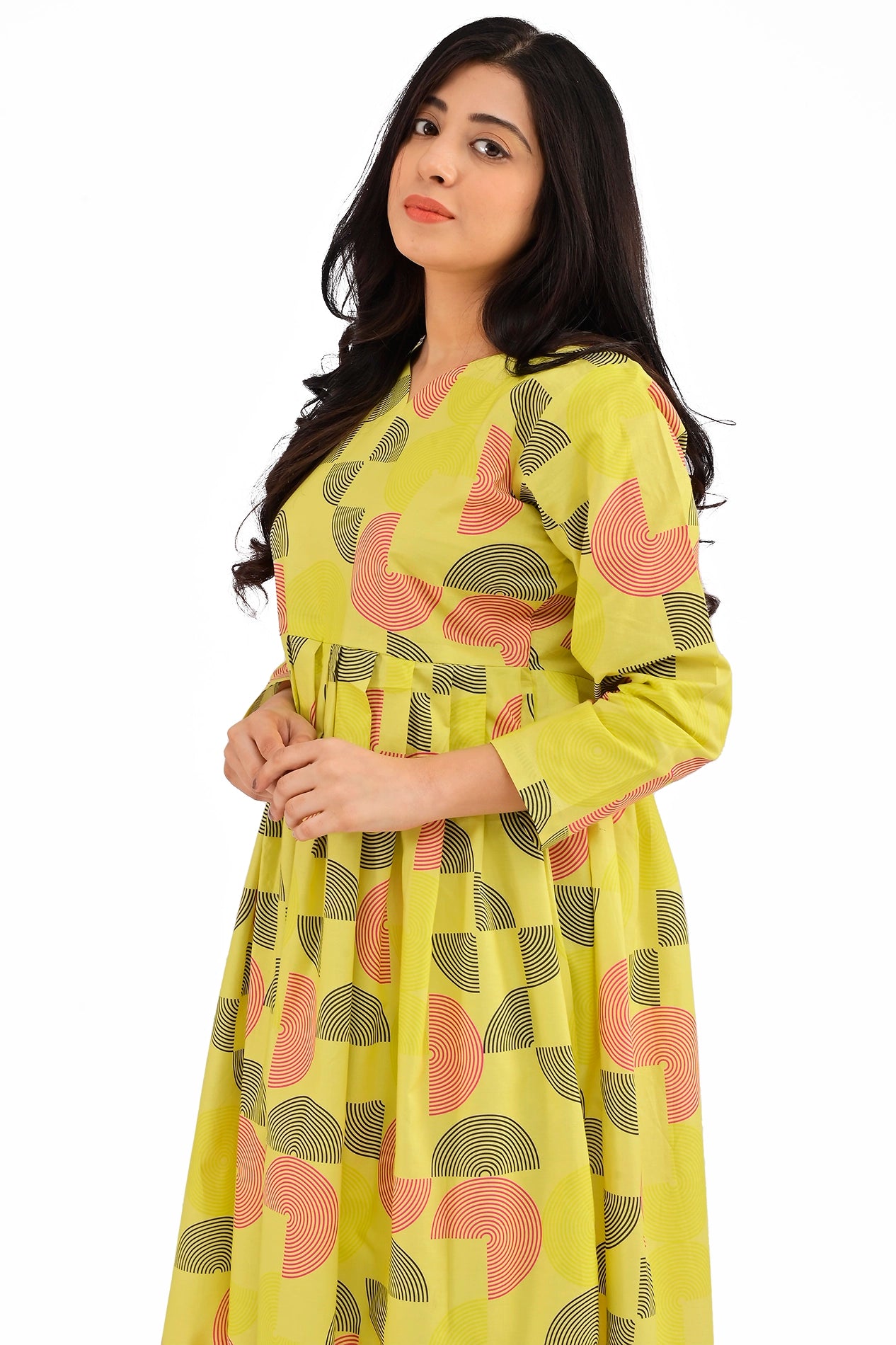 A close-up of the model wearing the yellow geometric print dress, focusing on the round neckline and minimalistic design. The contemporary pattern is displayed prominently across the bodice and sleeves. BOLDSTEP BOLDSTEP.PK
