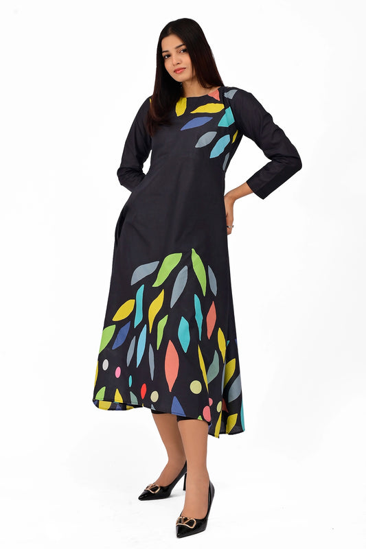 A-line black dress with multicolored abstract leaf motifs scattered across the lower half and upper bodice, worn by a model standing confidently with a slight tilt. BOLDSTEP BOLDSTEP.PK