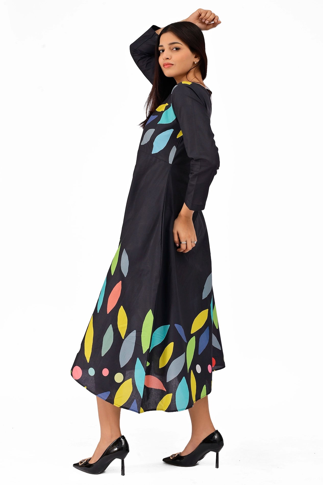Side view of a black dress showcasing full-length sleeves and a vibrant multicolored leaf design, paired with black heels for a chic look. BOLDSTEp BOLDSTEP.PK