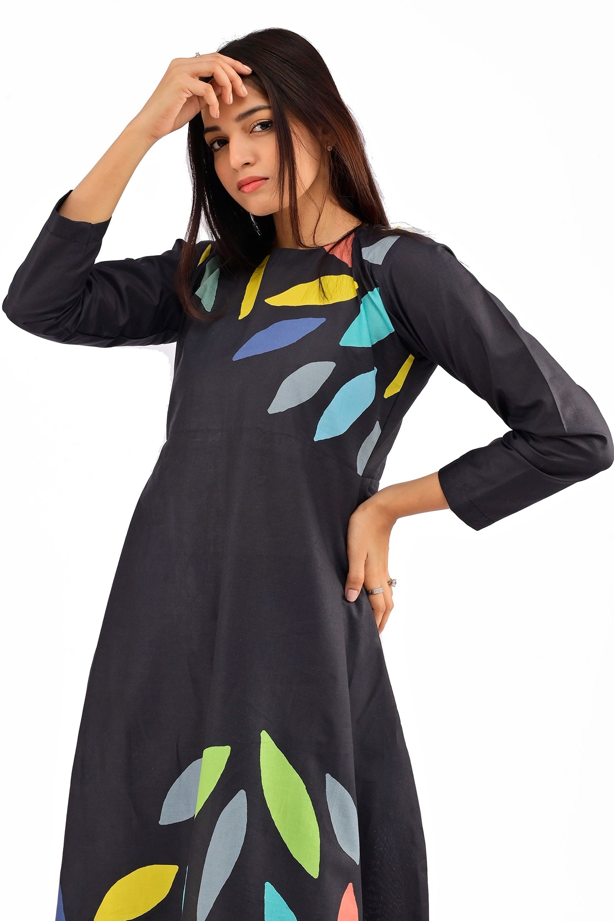 Close-up of a model wearing a black dress with a round neckline and multicolored abstract motifs on the upper bodice, exuding sophistication. BOLDSTEP BOLDSTEP.PK