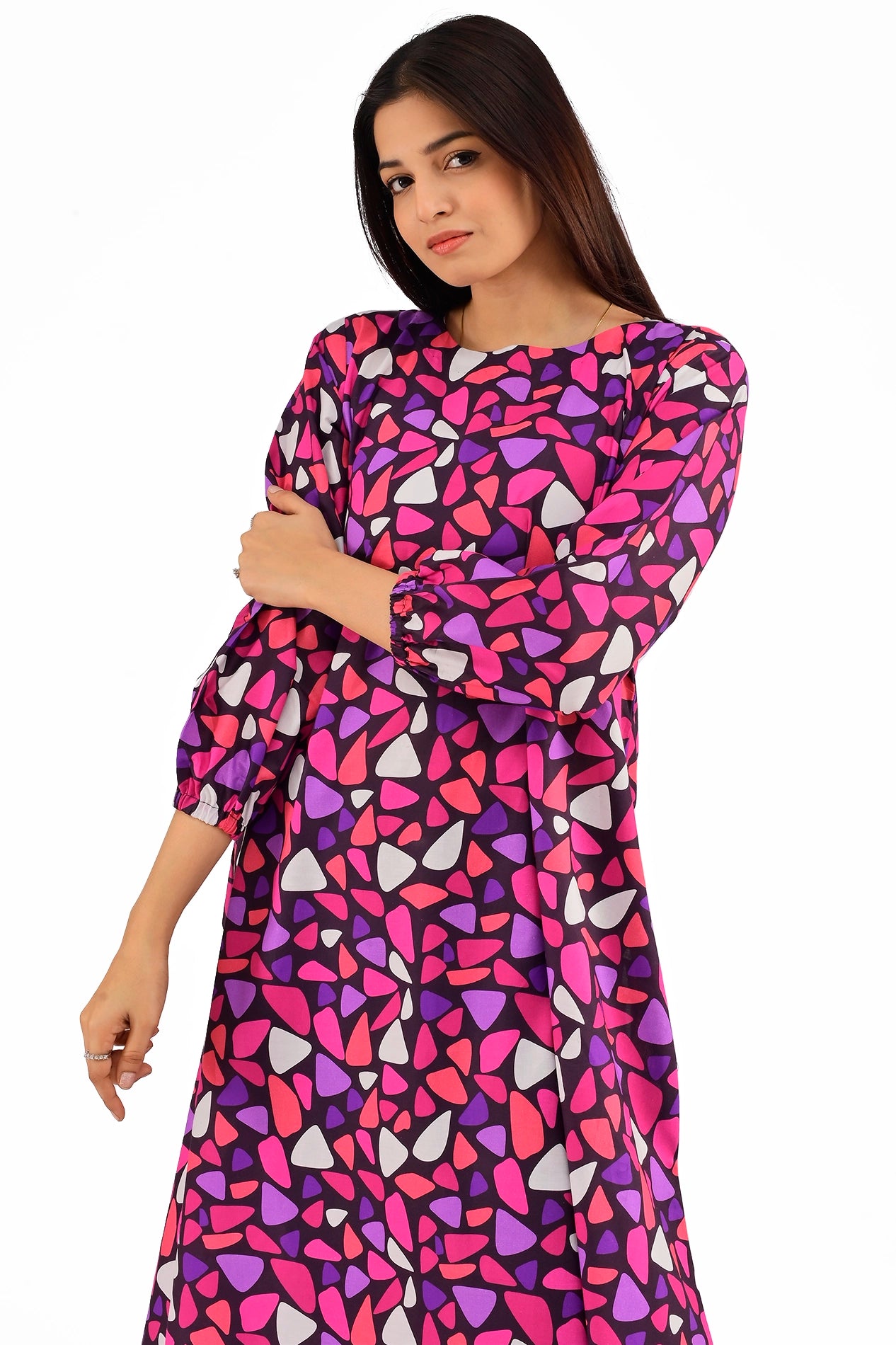 Close-up of a woman wearing a bright mosaic-patterned dress, emphasizing the round neckline and detailed geometric design. BOLDSTEP BOLDSTEP.PK