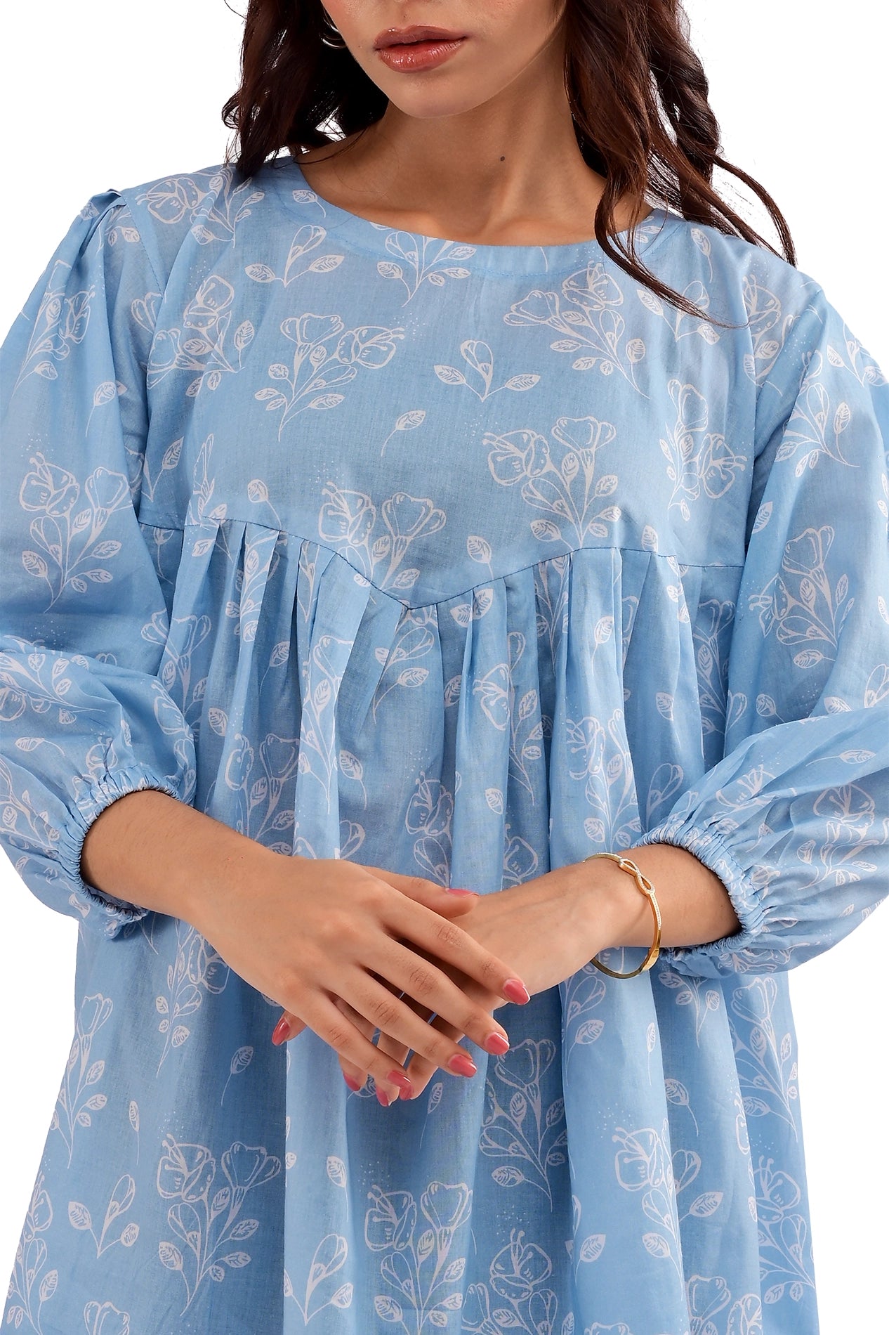 A zoomed-in shot highlighting the tunic’s sleeve, elasticated cuffs, and delicate floral print on breathable lawn fabric