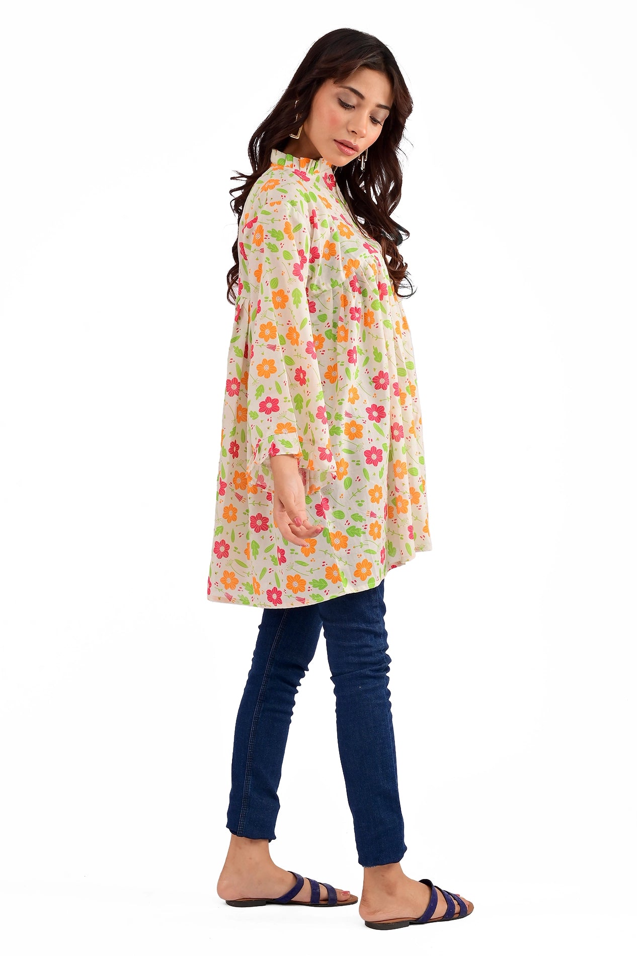 A side profile of the model in the same floral tunic, showcasing its flowy silhouette and delicate floral pattern