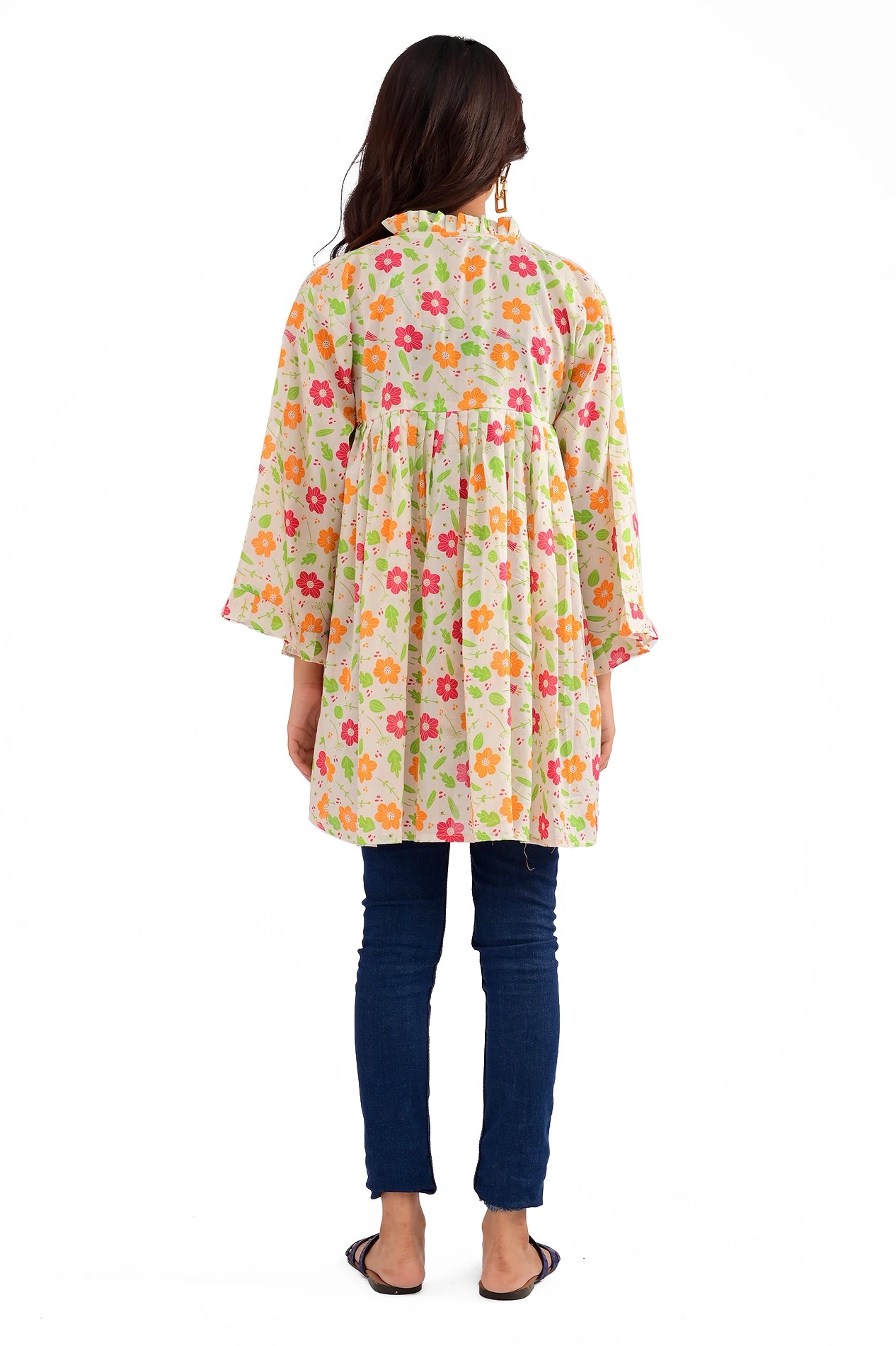 The model facing away, displaying the back design of the floral-printed tunic with a pleated yoke and a comfortable fit
