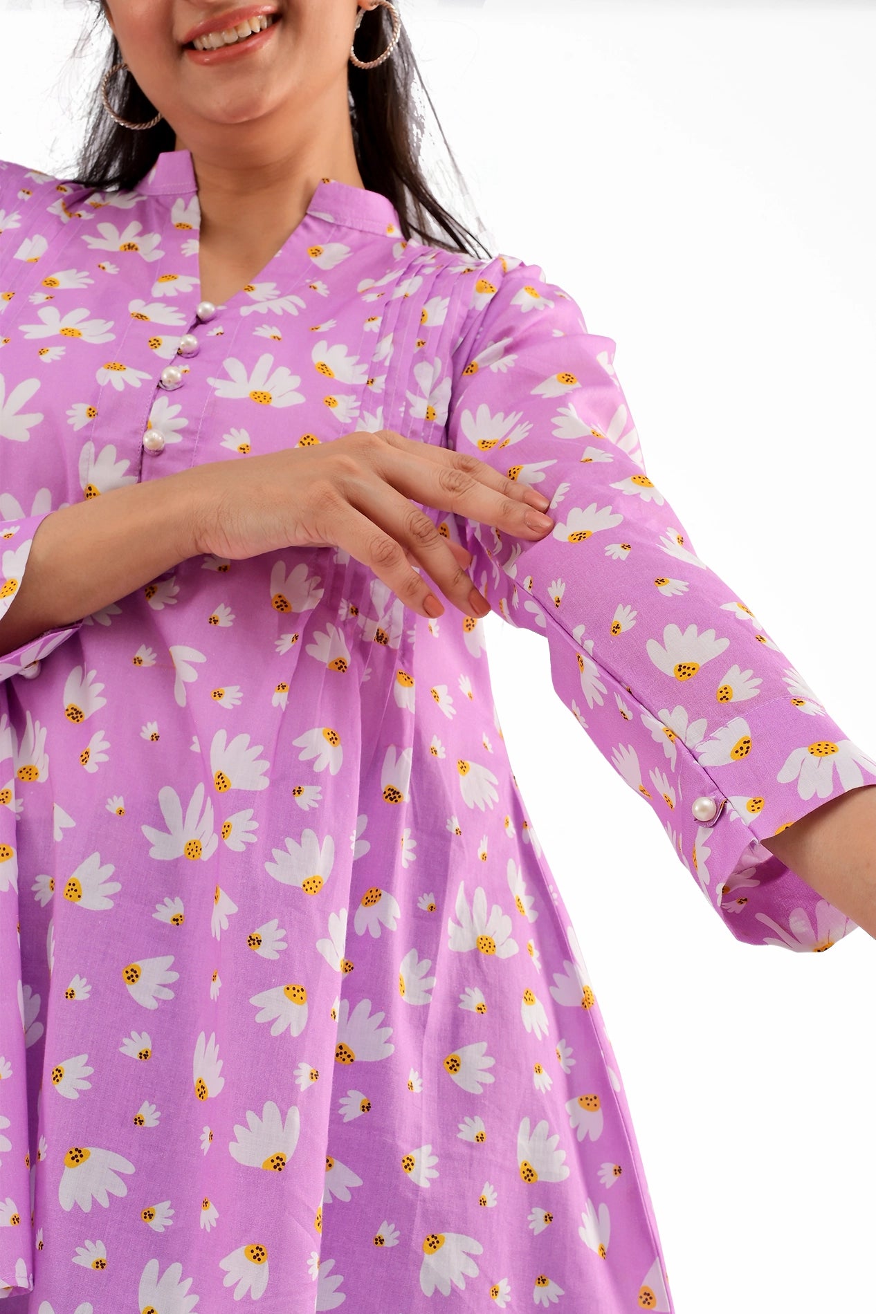 A zoomed-in view of the sleeve, displaying the pearl button cuff and delicate floral pattern