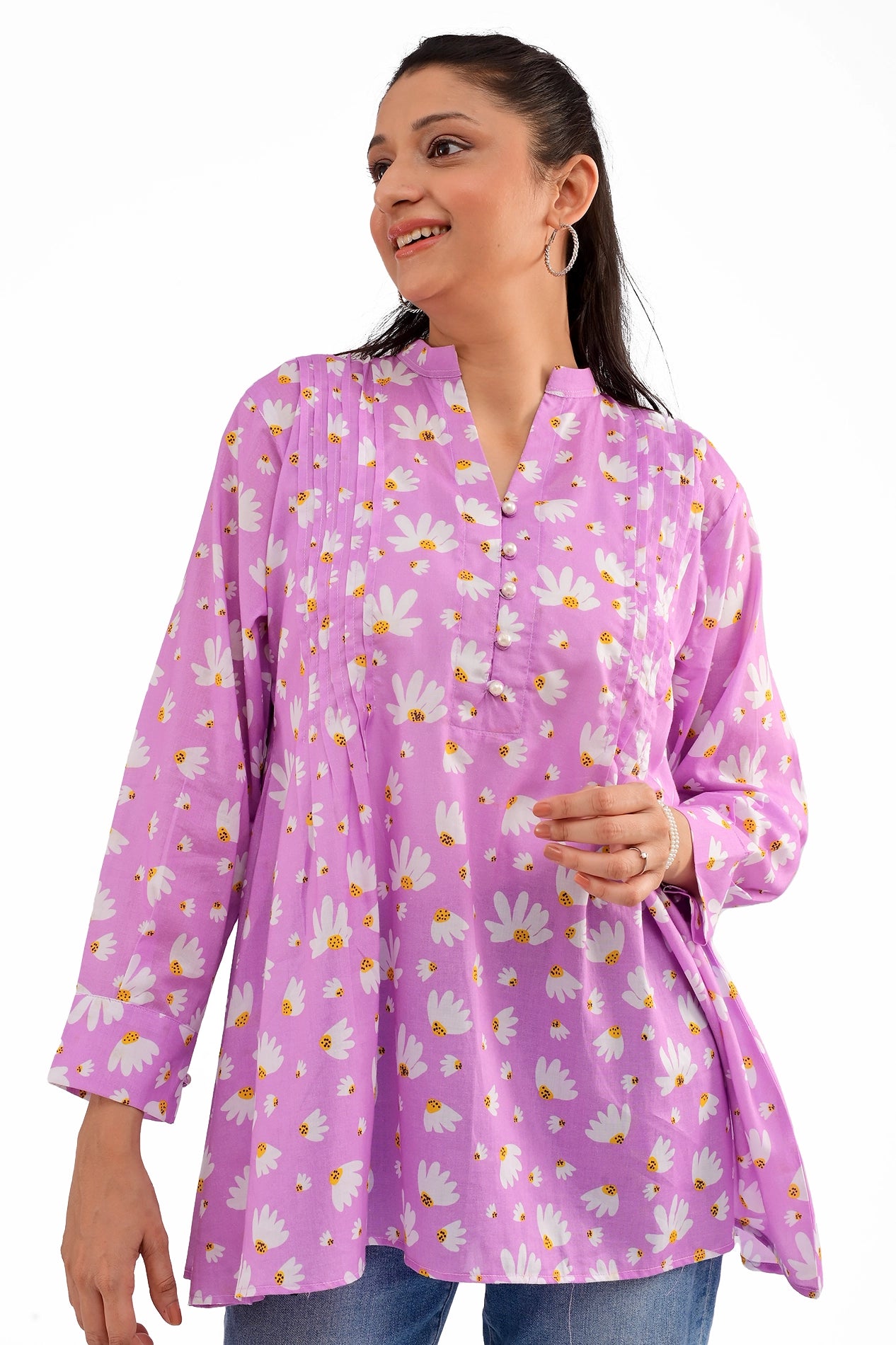 A close-up of the tunic’s upper section, highlighting the pleated details, button embellishments, and daisy print on soft lavender fabric