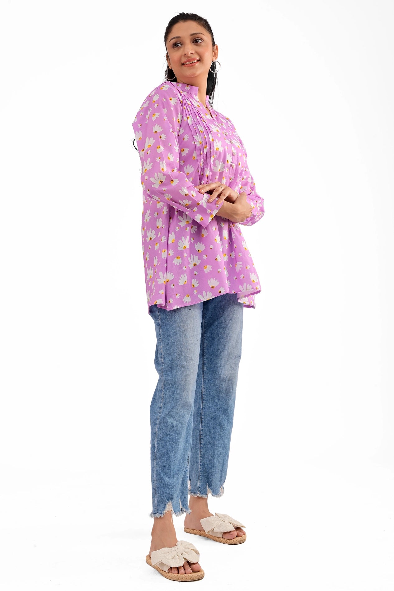 A side-angle shot of the model in the lavender floral tunic, showcasing its flowy fit and full sleeves