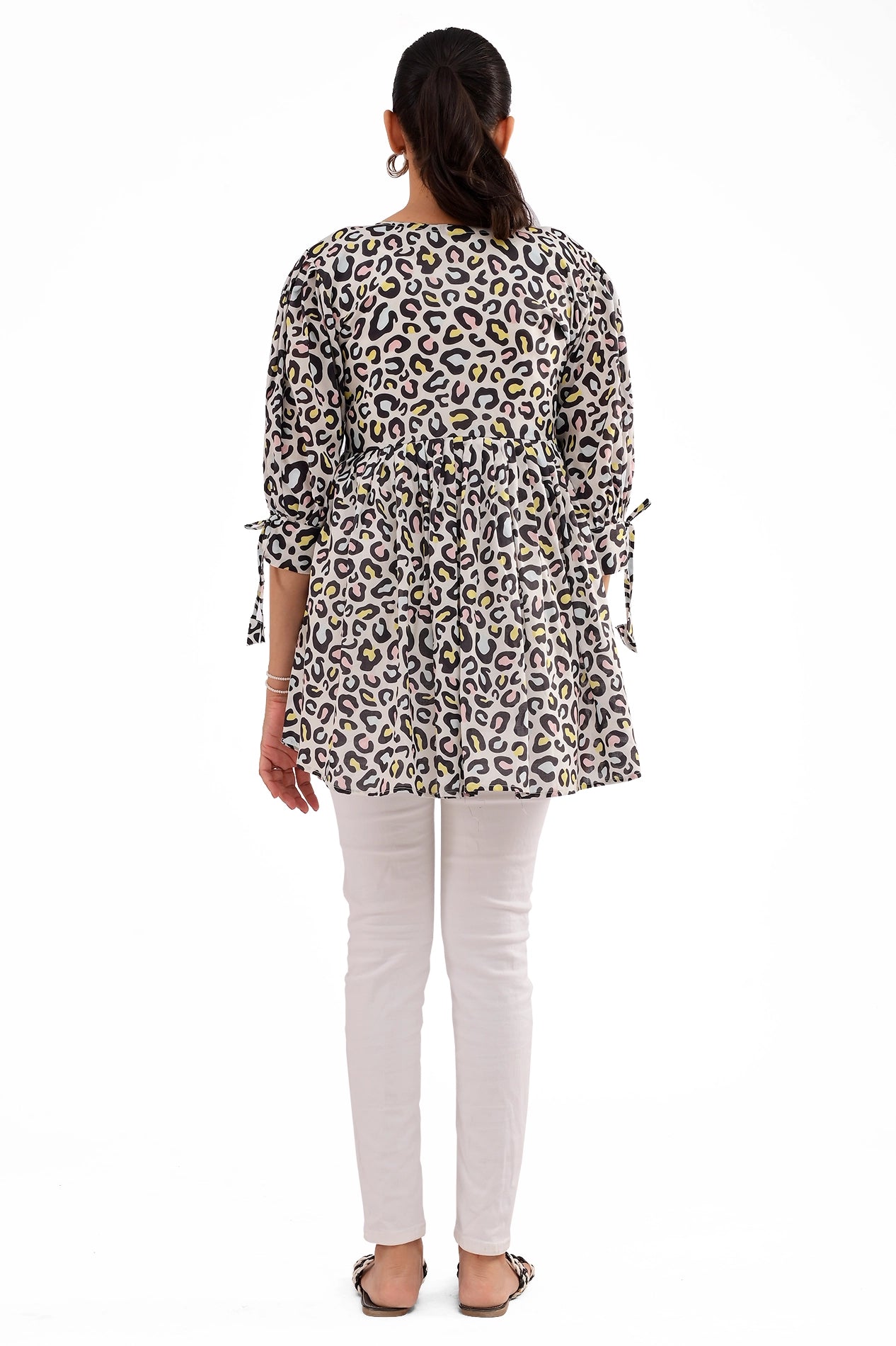 A rear view of the tunic, showcasing its relaxed fit and stylish gathered waist. The lightweight fabric provides a comfortable and fashionable look for everyday wear