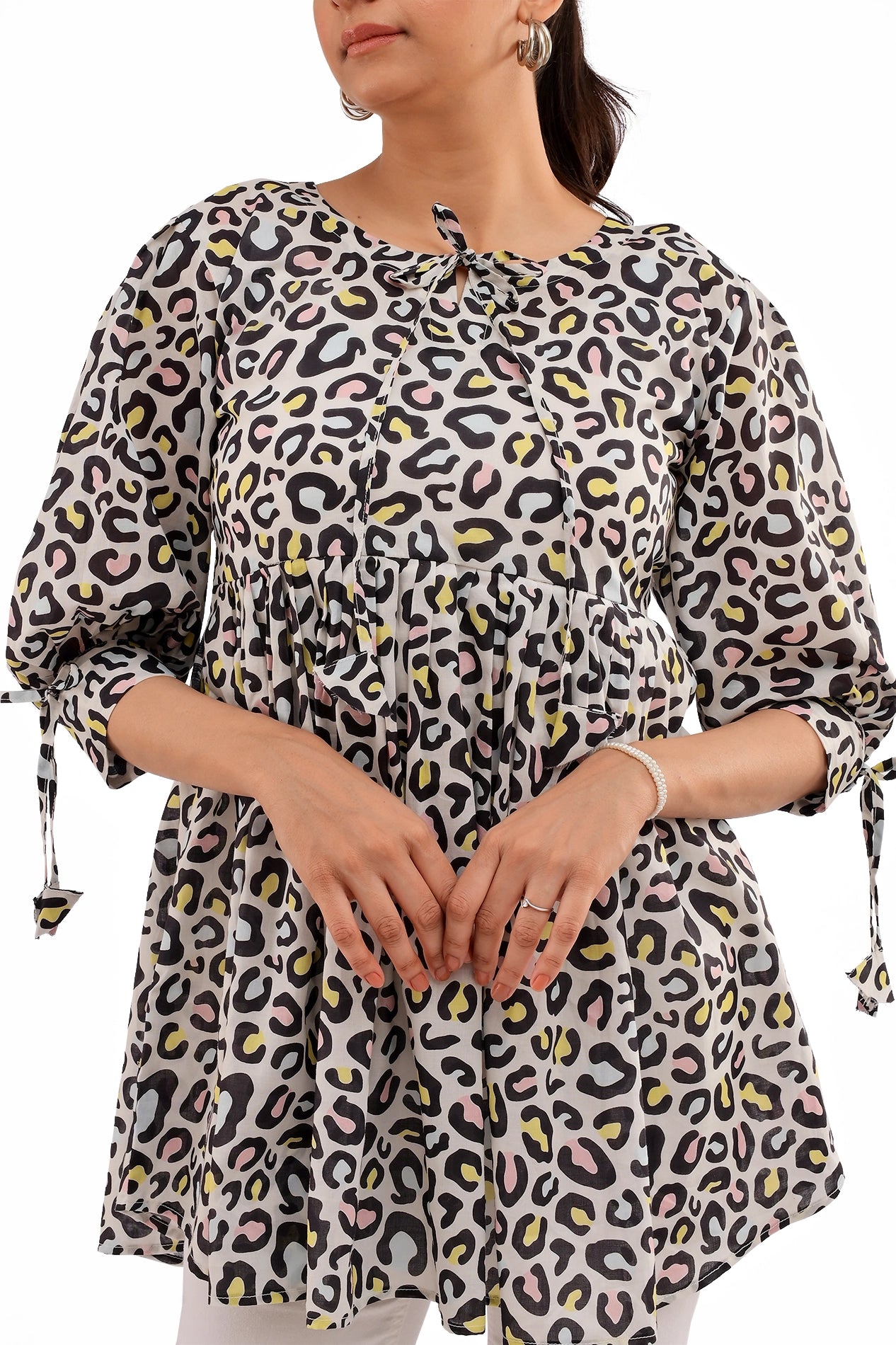 A closer look at the sleeve and waist gathering of the tunic, showing the flowy fabric and intricate print design. The subtle color contrast enhances the visual appeal