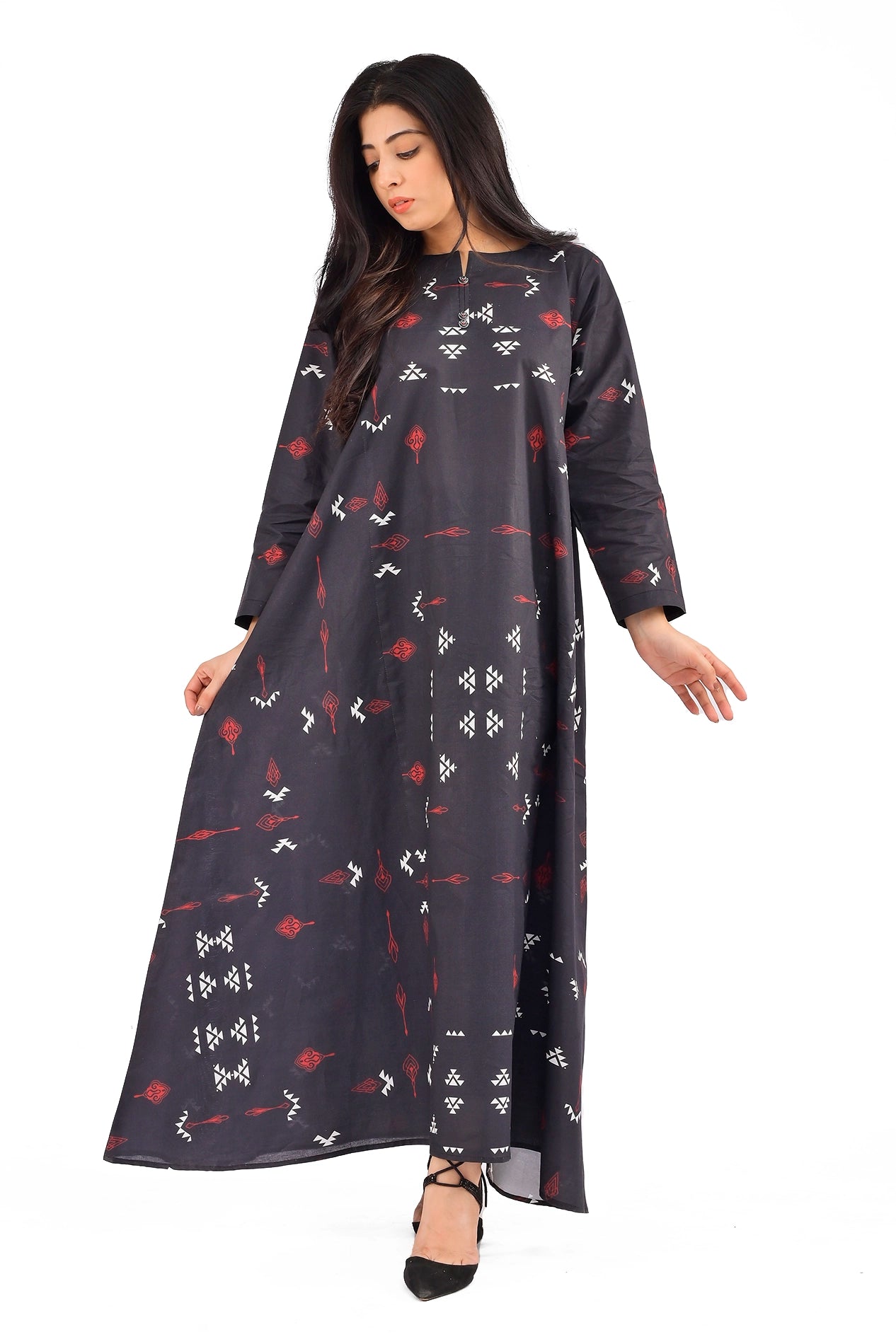 The model wearing a long black printed dress with intricate red and white geometric patterns, full sleeves, and a modest round neckline, showcasing the elegant design of the outfit. BOLDSTEP BOLDSTEP.PK