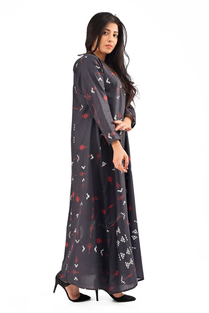 Side profile of a model wearing a flowing black maxi dress with abstract red and white prints, paired with black heels, highlighting the dress's graceful silhouette. BOLDSTEP. BOLDSTEP.PK