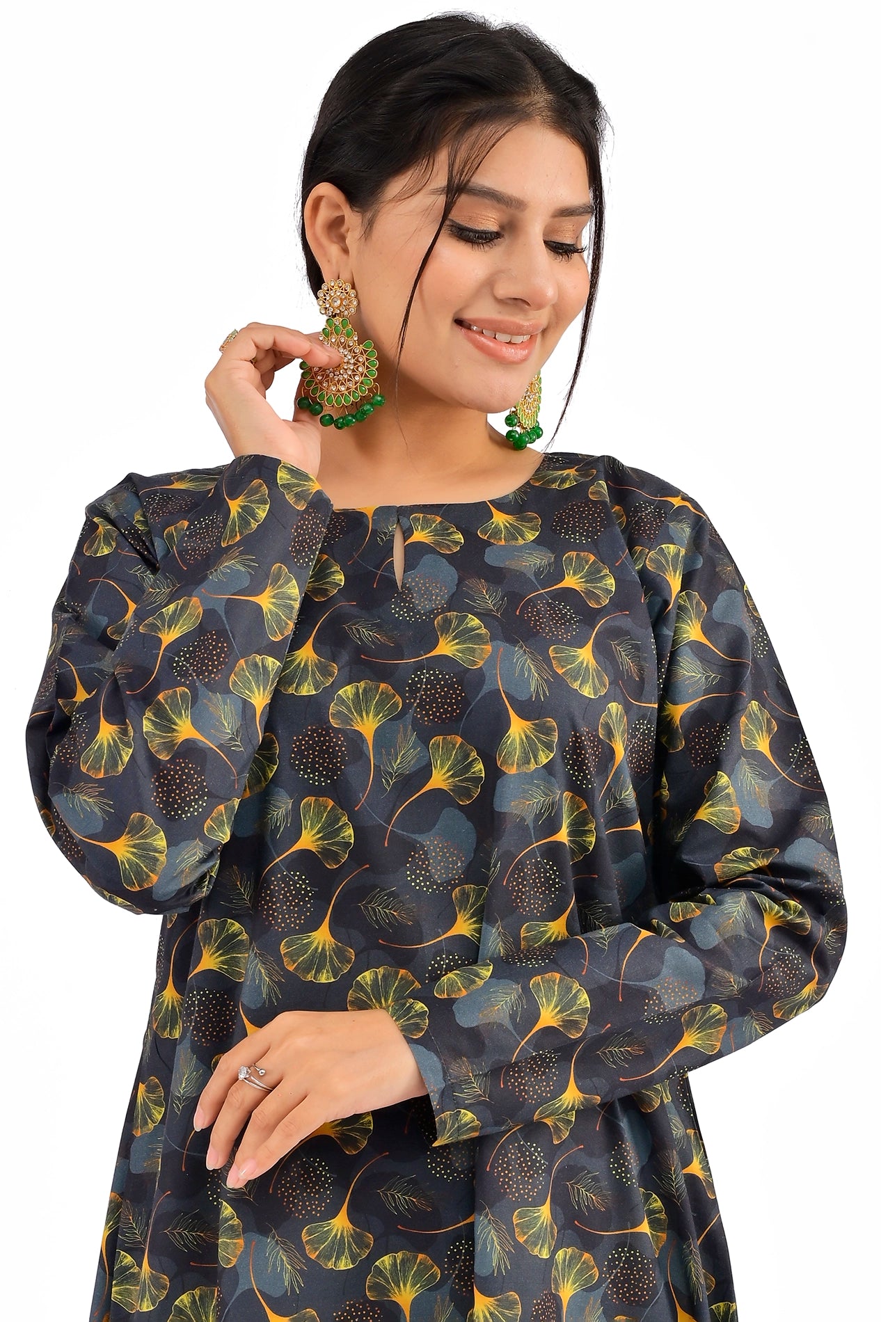 A close-up of the model wearing the black ginkgo leaf patterned dress, focusing on the rounded neckline with a slit, full sleeves, and intricate leaf detailing BOLDSTEP BOLDSTEP.PK