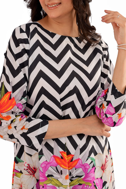 A detailed view of the three-quarter sleeve showcasing the mix of black and white chevron pattern with digitally printed flowers in shades of pink, orange, and white.