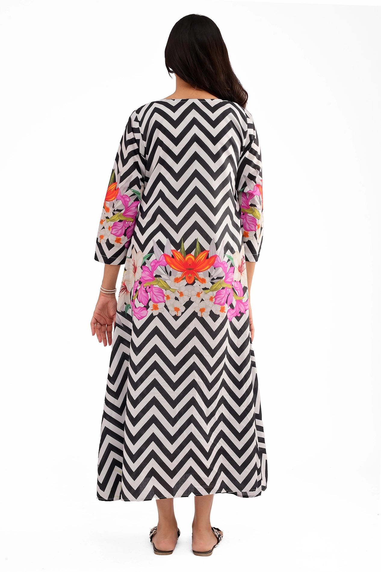 The back view of the dress, featuring the continuous chevron pattern with symmetrical floral digital prints on the lower back and sleeves.