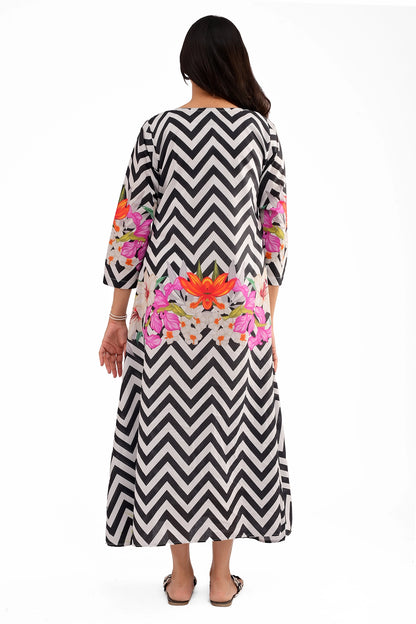 The back view of the dress, featuring the continuous chevron pattern with symmetrical floral digital prints on the lower back and sleeves.