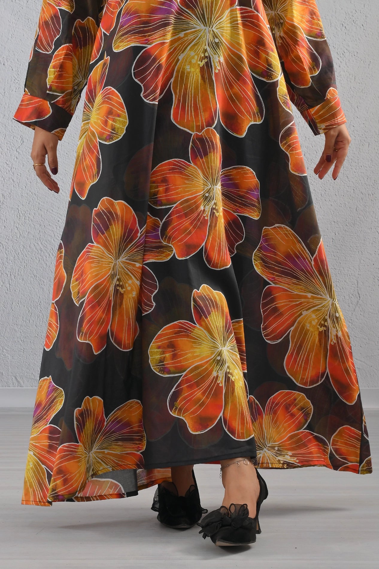 Lower hem close-up of BOLDSTEP floral cotton maxi dress showing vivid orange, red, and yellow blooms on a black base – elegant craftsmanship | BOLD STEP | BOLDSTEP.PK | BOLDSTEP STORE.