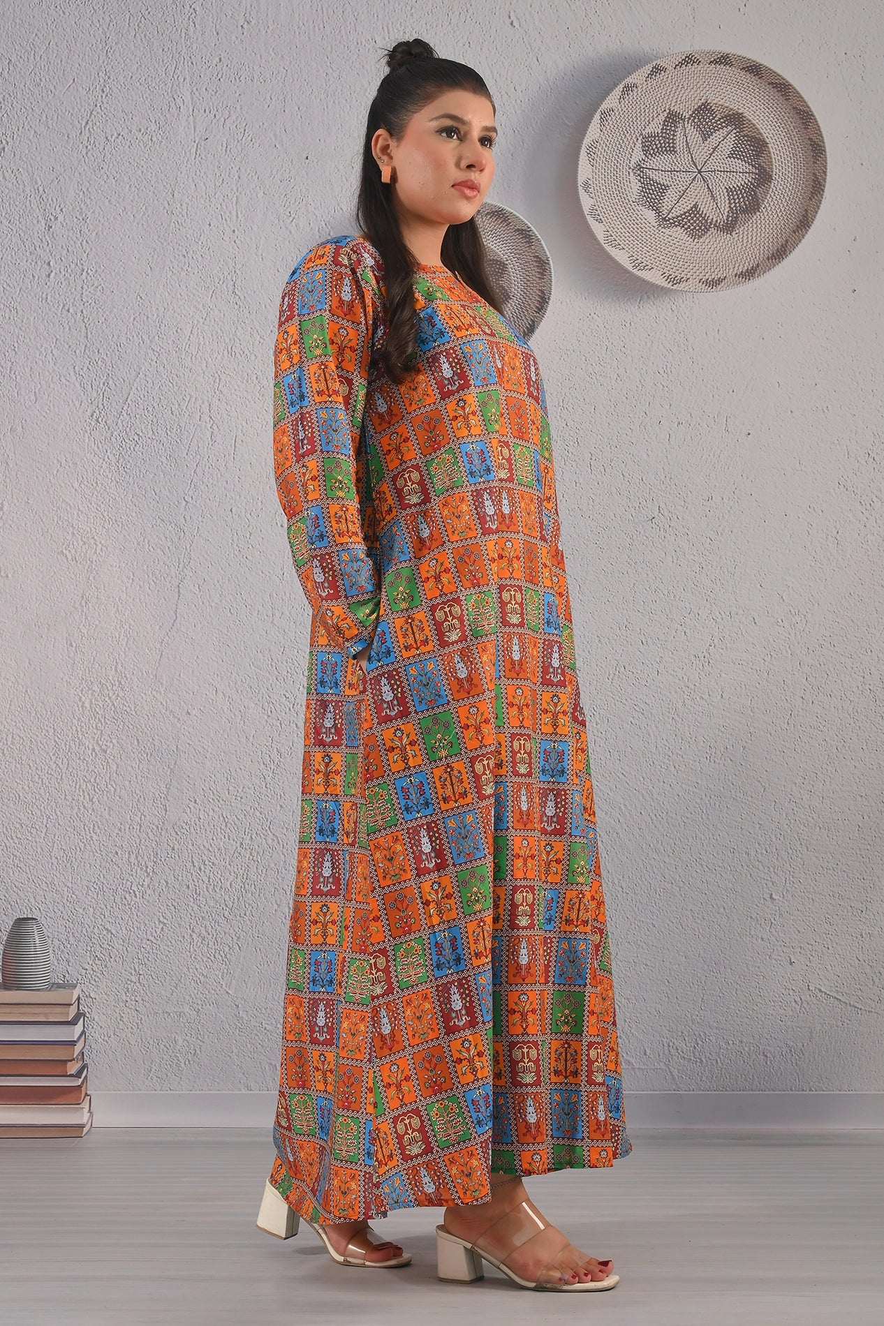 BOLDSTEP product video showcasing a multicolor ethnic printed maxi dress with orange, blue, green, and maroon square motifs. The model walks and poses to display the flowy silhouette, traditional block print design, and full-length sleeves – premium cultural fashion by BOLD STEP | BOLDSTEP.PK | BOLDSTEP STORE.