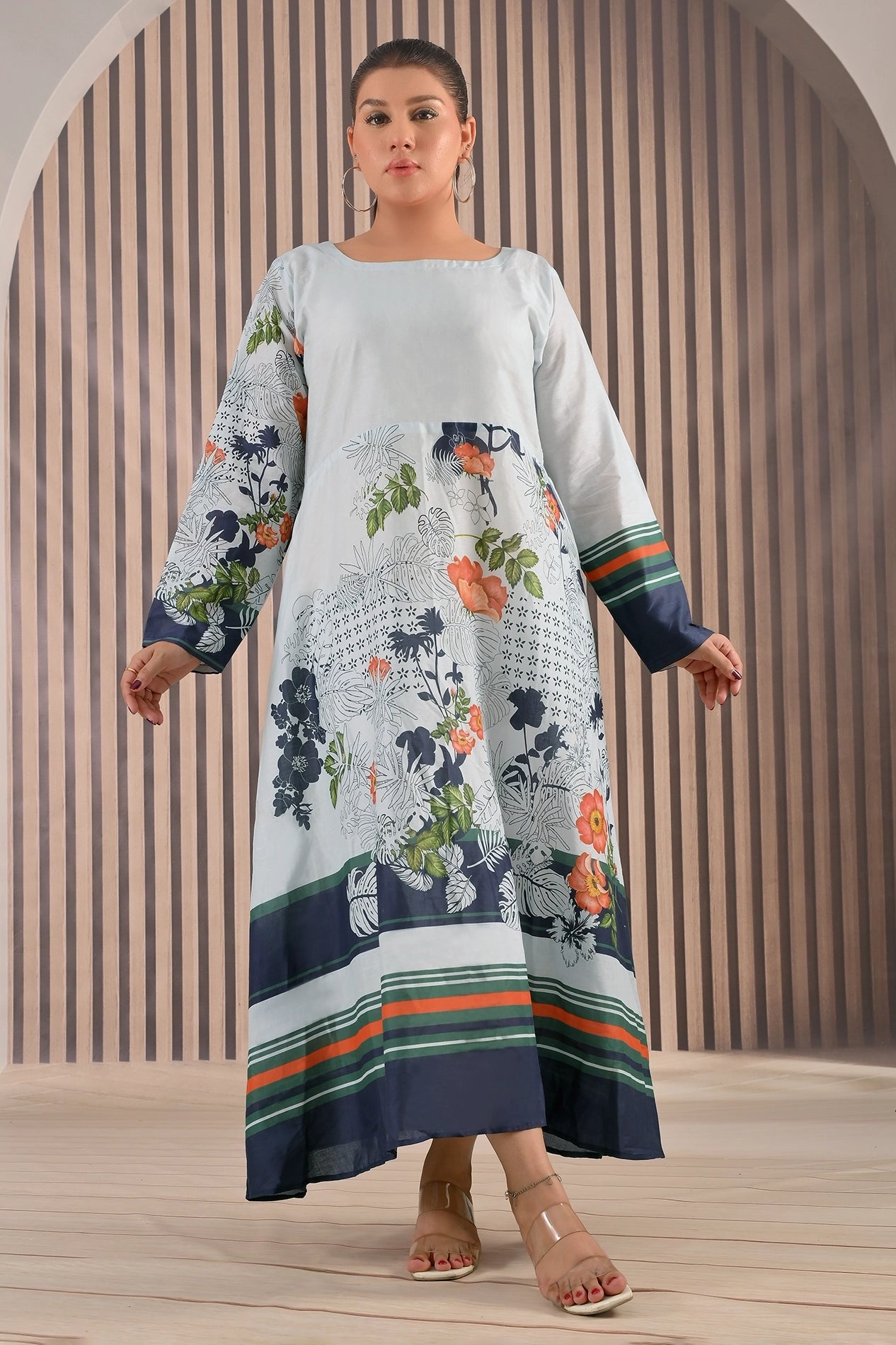 BOLDSTEP product video featuring a white cotton maxi dress with navy, green, and orange floral prints. The model showcases the flowy A-line silhouette, striped hemline, and full sleeves in elegant studio lighting — highlighting BOLDSTEP’s premium stitched craftsmanship | BOLD STEP | BOLDSTEP.PK | BOLDSTEP STORE.